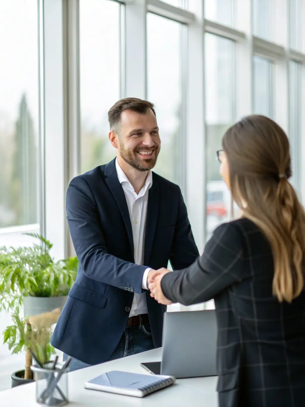 A professional businessman confidently shaking hands with a financial advisor in a modern office setting, symbolizing trust and partnership.
